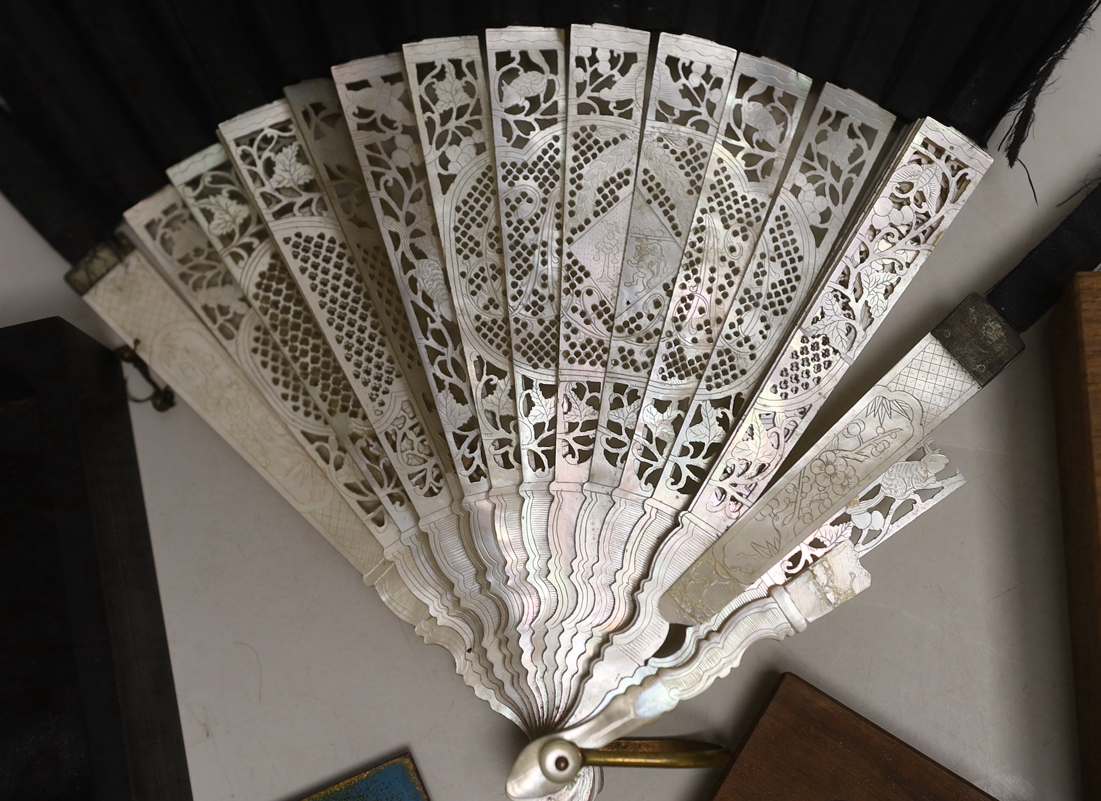 A mother of pearl guard fan and two enamel topped boxes, largest enamel topped box 12.5cm x 10cm